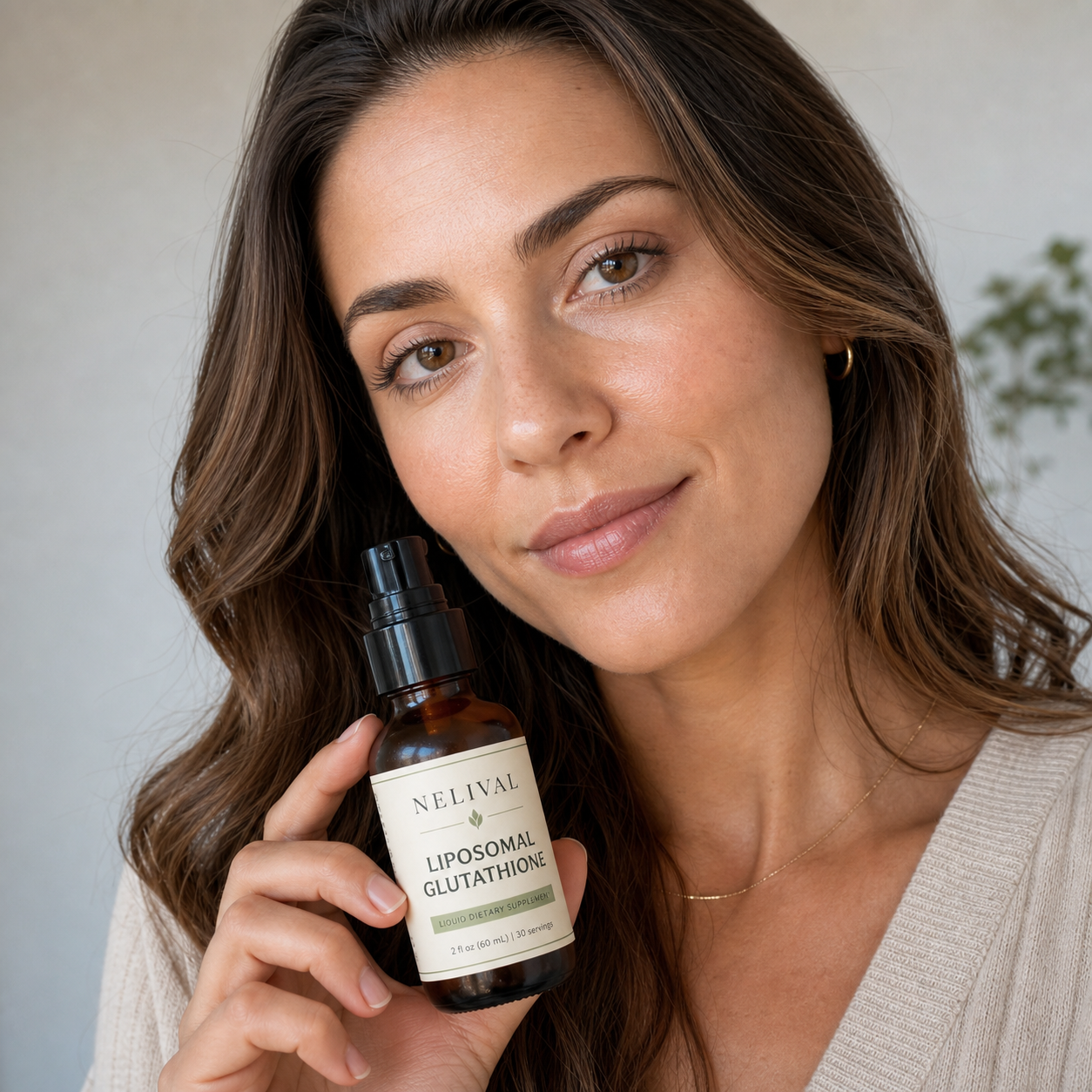 Woman holding Nelival Liposomal Glutathione bottle
